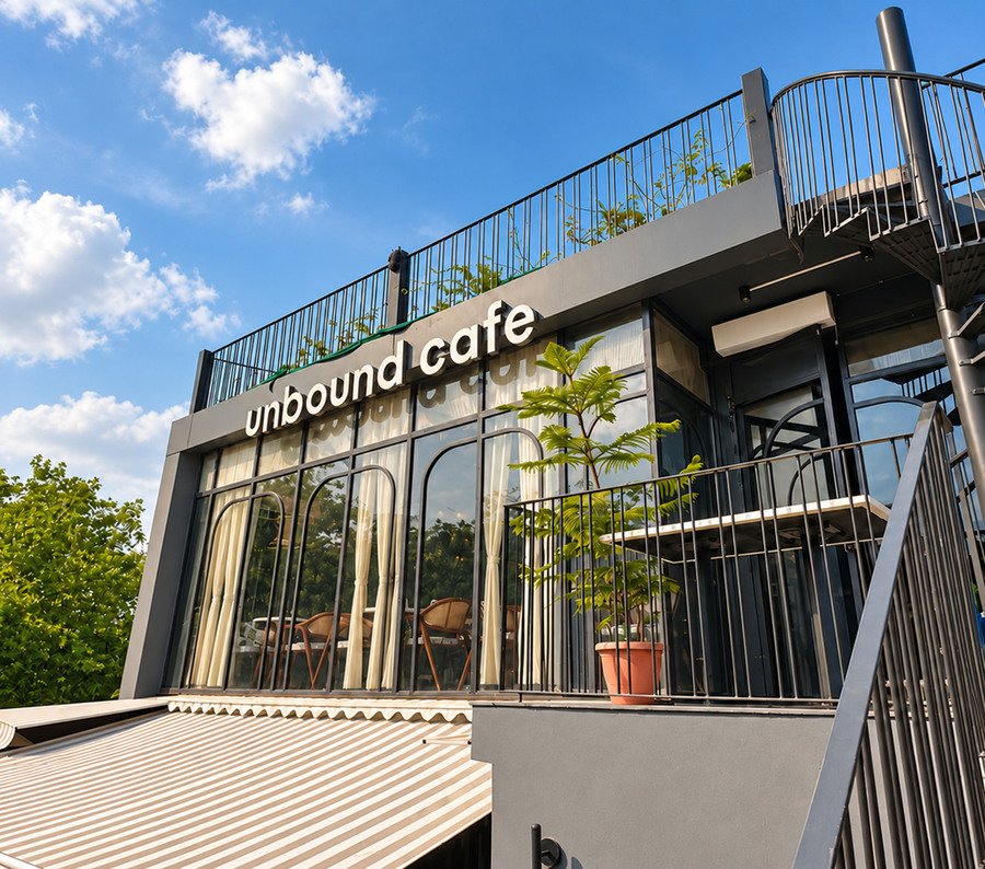 The side of the building by day: the first-floor balcony, the rooftop railing and the spiral stairs