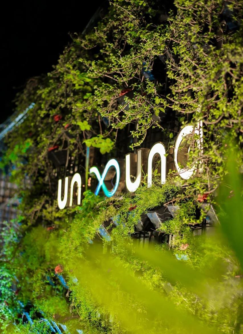 The lit UnBound sign in the green wall at night